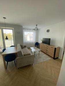 a living room with a couch and a table at Apartament Czartoryskich House z miejscem postojowym w garażu podziemnym in Puławy