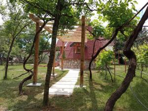 a house with a wooden roof on top of a group of trees at Seosko domaćinstvo Peković in Danilovgrad