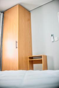 a wooden cabinet in a room with a bed at Lelwapa Stay in Gaborone +6 photos