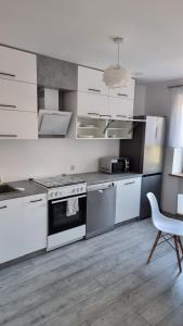 cocina con electrodomésticos blancos, mesa y silla en Oscar Apartment, en Ujazd