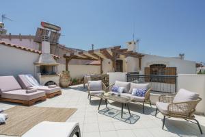 patio con sedie e camino sul tetto di Villa Kamares, a 1912 stonebuilt unique estate with heated pool! a Panormos