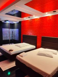 two beds in a room with red walls at Motel Vip Olimpia in Olímpia +19 photos