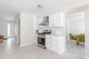 a white kitchen with a stove and a table at P&Ds Harmony House 20 Mins to Airport & Downtown in Decatur