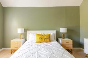 a bedroom with green walls and a bed with a yellow pillow at P&Ds Harmony House 20 Mins to Airport & Downtown in Decatur