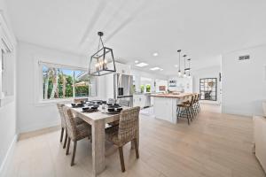 ココアビーチにあるThe Cocoa Plum - A Quiet Riverfront Pool Home Near Beachのテーブルと椅子のあるキッチンとダイニングルーム