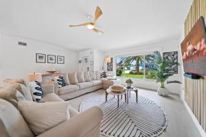 ココアビーチにあるThe Cocoa Plum - A Quiet Riverfront Pool Home Near Beachのリビングルーム(白い家具、天井ファン付)