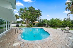 ココアビーチにあるThe Cocoa Plum - A Quiet Riverfront Pool Home Near Beachのパティオ付きの庭のスイミングプール