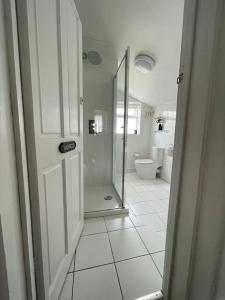 a white bathroom with a shower and a toilet at Cosy 2bed home with games room in Oxford