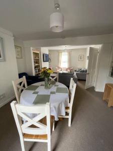 a dining room with a table and chairs and a living room at Cosy 2bed home with games room in Oxford
