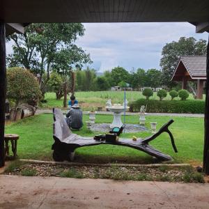 a sculpture of a person sitting at a table in a park at Baan Rai Pontip Homestay in Ban Hoep