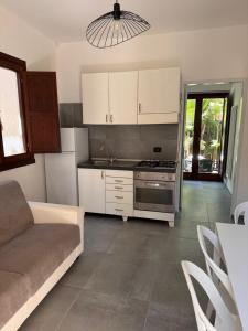 a kitchen with a couch and a stove top oven at Villaggio Silvia in Castellabate