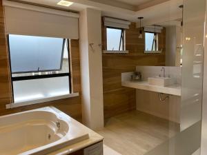 un bagno con vasca, lavandino e specchio di Hotel Palace Cachoeiras a Cachoeiras de Macacu Altre 24 foto