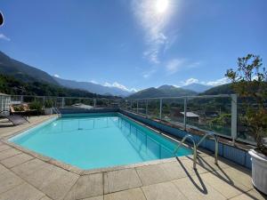una grande piscina con le montagne sullo sfondo di Hotel Palace Cachoeiras a Cachoeiras de Macacu