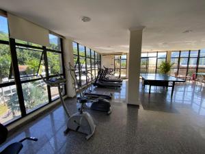 una palestra con macchinari per il cardio-fitness, tavolo e finestre di Hotel Palace Cachoeiras a Cachoeiras de Macacu
