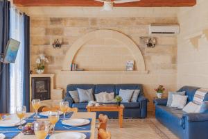 a living room with a blue couch and a table at Ta Danjela Villa Sleeps 8 with Pool in Xagħra