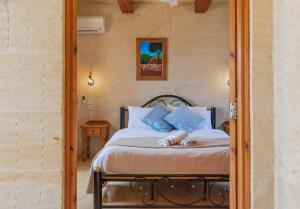 a bedroom with a bed with blue pillows at Ta Danjela Villa Sleeps 8 with Pool in Xagħra +18 photos