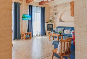 a living room with a blue couch and a table at Ta Danjela Villa Sleeps 8 with Pool in Xagħra