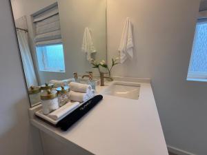 a white bathroom with a sink and a mirror at Minutes to Rock City, Ruby Falls, & Downtown in Chattanooga +31 photos