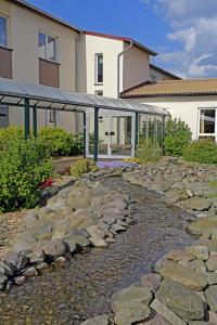 a stone path in front of a house with a building at Hotel Falkenhagen in Pritzwalk