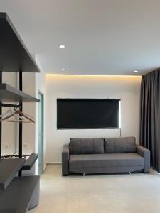 a living room with a couch and a flat screen tv at Adele Hotel Ksamil in Ksamil