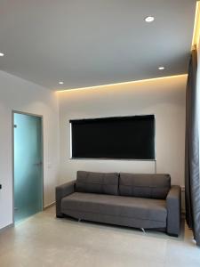 a living room with a couch and a flat screen tv at Adele Hotel Ksamil in Ksamil