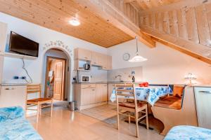 kuchnia i salon ze stołem i krzesłami w obiekcie Residence Villa Toni w mieście San Vigilio di Marebbe