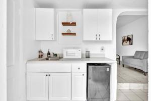 a white kitchen with a sink and a microwave at Downtown Hollywood Beach Blvd Studio Getaway in Hollywood