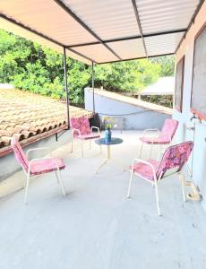 a group of pink chairs sitting on a patio at Departamento Batti in Asuncion