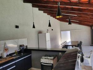 a kitchen with a counter top and a table in it at Casa de Temporada Uberaba com Piscina Aquecida in Uberaba