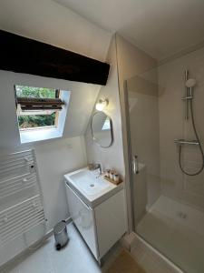 a white bathroom with a shower and a sink at Le Cottage du Domaine in Boissettes +14 photos