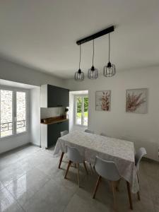 a kitchen and dining room with a table and chairs at Le Cottage du Domaine in Boissettes