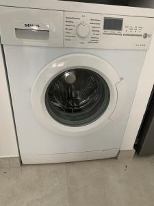 a white washing machine sitting in a room at Le Cottage du Domaine in Boissettes
