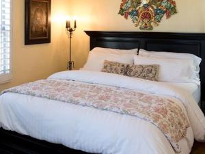 a bedroom with a large bed with white sheets and pillows at Half Moon Bay Inn in Half Moon Bay +1 photo