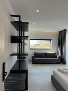 a living room with a couch and a black staircase at Adele Hotel Ksamil in Ksamil