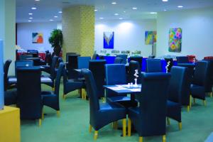 a dining room with blue chairs and tables at Delmar Hotel Matrouh in Marsa Matruh