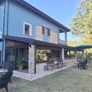 a house with benches and tables in a yard at Residenza Mistral in Rende