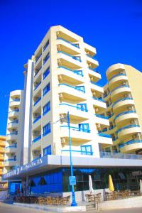 a large apartment building with a bench in front of it at Delmar Hotel Matrouh in Marsa Matruh