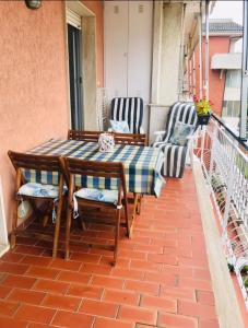 アルベンガにあるCasa vacanze Patriziaのバルコニーにテーブルと椅子が置かれたパティオ +2枚の写真