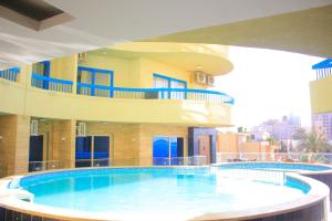 a large swimming pool in front of a building at Delmar Hotel Matrouh in Marsa Matruh