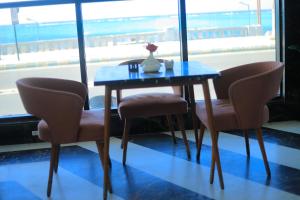 a blue table with two chairs and a vase on it at Delmar Hotel Matrouh in Marsa Matruh