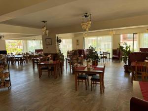 a dining room with tables and chairs and windows at Royal Life Poseidon Residences Long Beach in Iskele