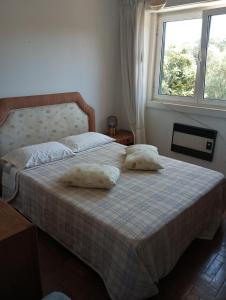 a bedroom with a bed with two pillows on it at Casa de alojamento local (T2) Queluz de Baixo in Oeiras