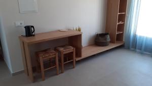 a small table and two stools in a room at Talos in Sougia