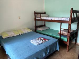 a bedroom with two bunk beds and a blue bed at Casa agradável in Indaial