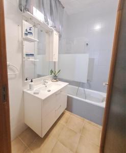 a white bathroom with a sink and a bath tub at Apartamento a pie de playa en San Marcos in San Marcos