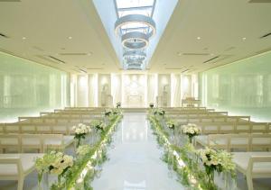 ein Festsaal mit einem langen Mittelgang, der mit weißen Blumen geschmückt ist in der Unterkunft Oriental Hotel Hiroshima in Hiroshima