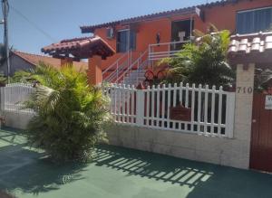 ein weißer Zaun vor einem Haus in der Unterkunft Pousada Mar e Sol in Saquarema