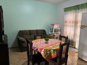 a living room with a table and a couch at Casa agradável in Indaial
