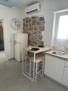 a kitchen with a white refrigerator and a sink at Crispi Guest House MMG in Olbia