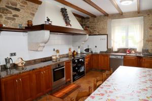 a kitchen with wooden cabinets and a table in it at Casa Nunes in Pazos